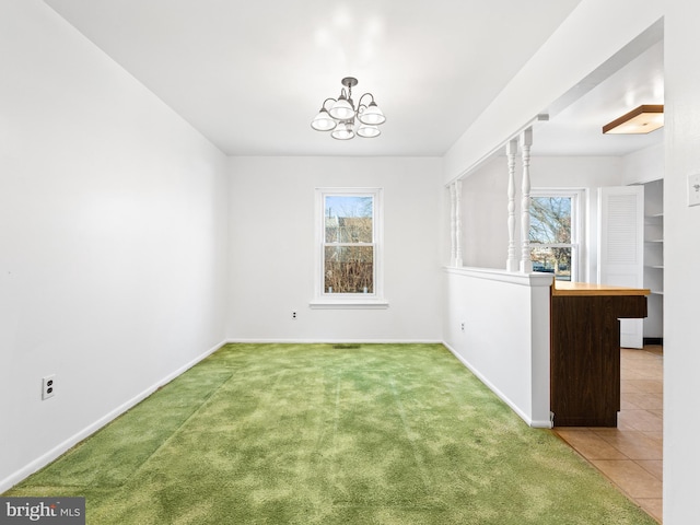 unfurnished dining area featuring carpet, plenty of natural light, and an inviting chandelier