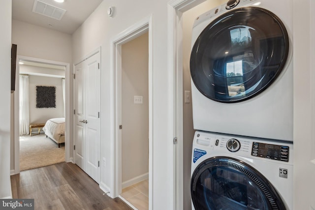 washroom featuring dark wood-type flooring and stacked washer and clothes dryer