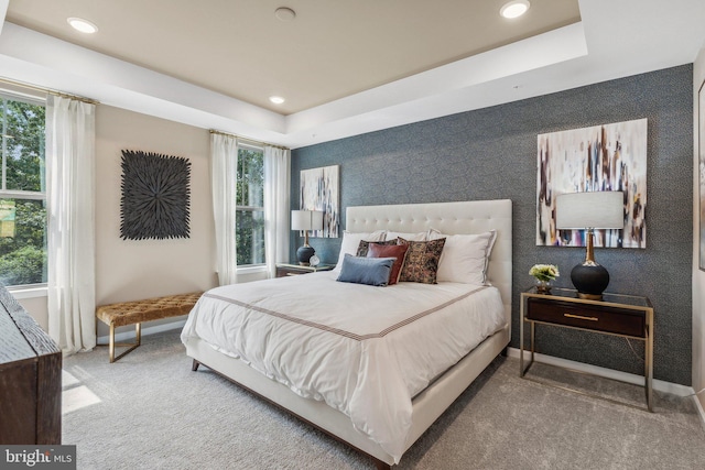 bedroom with a tray ceiling and carpet flooring