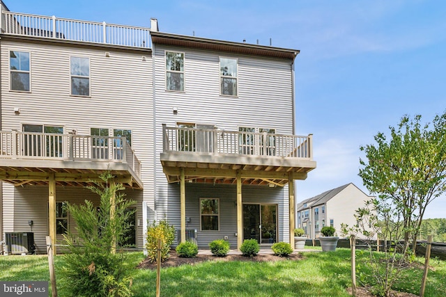 back of property featuring central air condition unit, a yard, and a balcony