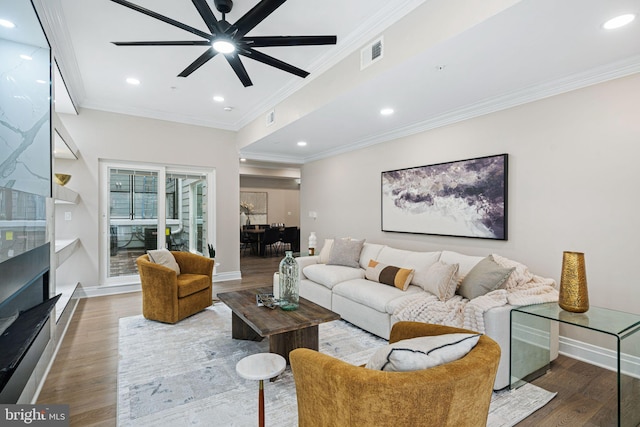 living room with hardwood / wood-style flooring, ceiling fan, and ornamental molding