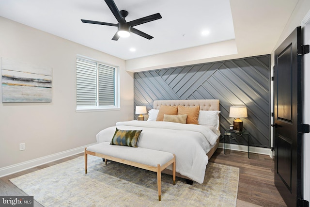 bedroom featuring dark wood-type flooring, ceiling fan, and wooden walls