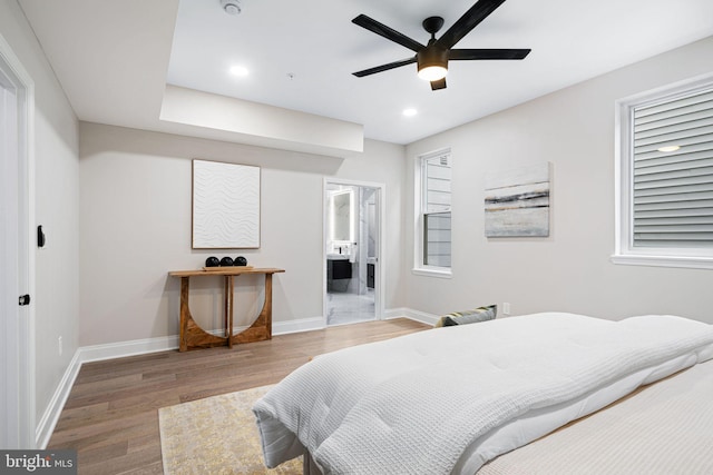 bedroom with ensuite bath, hardwood / wood-style flooring, and ceiling fan