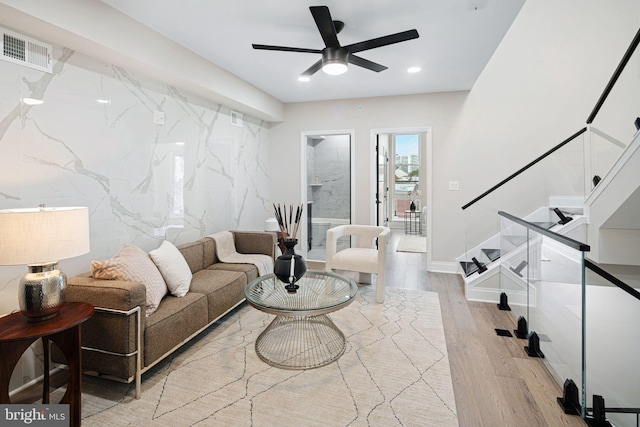 living room featuring light hardwood / wood-style flooring and ceiling fan