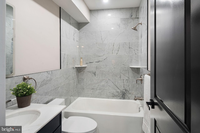 full bathroom with vanity, toilet, tile walls, and tiled shower / bath combo