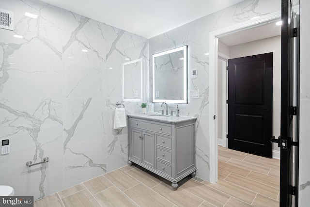 bathroom featuring vanity and tile walls