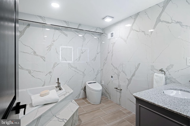 full bathroom featuring toilet, vanity, washtub / shower combination, and tile walls