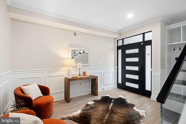 entrance foyer with light hardwood / wood-style floors and crown molding