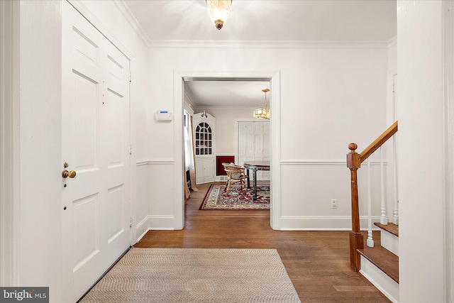 entryway with hardwood / wood-style floors and crown molding