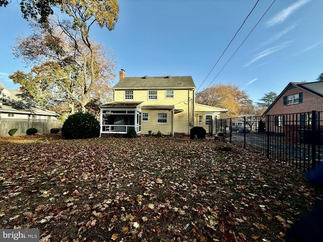 rear view of house featuring a sunroom