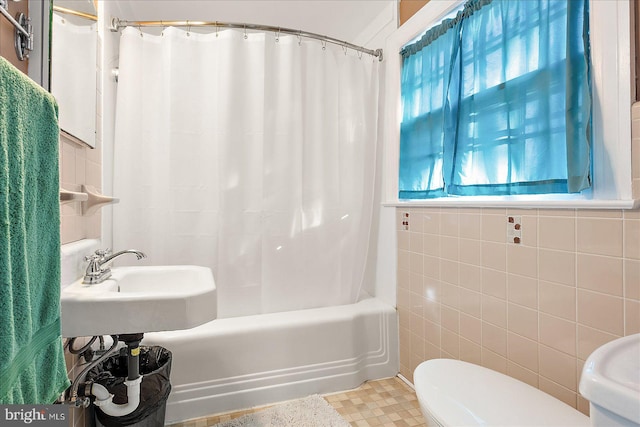 bathroom with shower / tub combo with curtain, toilet, and tile walls