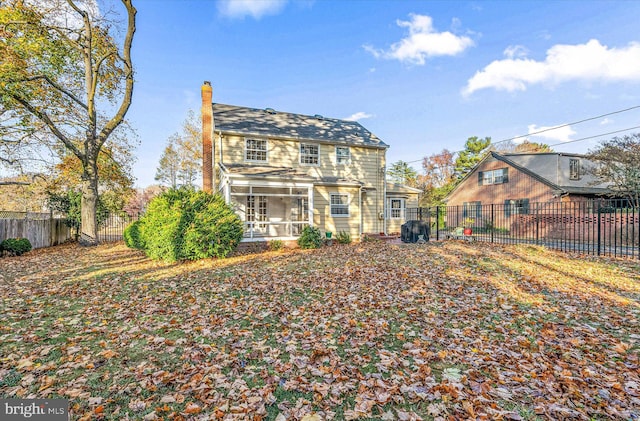 rear view of property featuring a sunroom