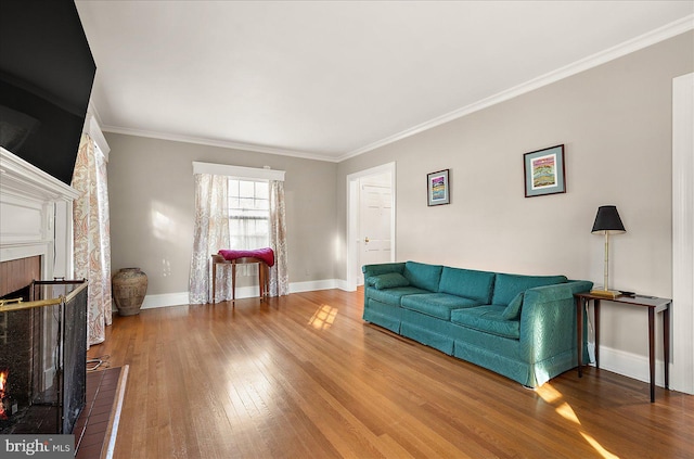 living room featuring a brick fireplace, hardwood / wood-style floors, and crown molding