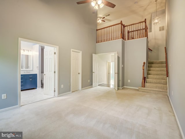 unfurnished bedroom with baseboards, visible vents, ensuite bathroom, and light colored carpet