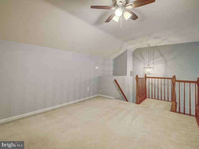 additional living space with carpet floors, an inviting chandelier, baseboards, and vaulted ceiling