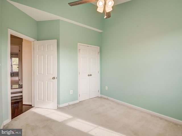 unfurnished bedroom with carpet, a closet, ceiling fan, and baseboards