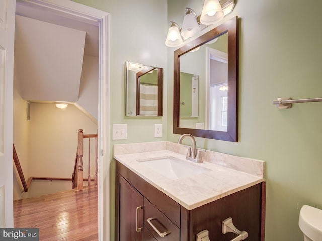 bathroom with toilet, wood finished floors, and vanity