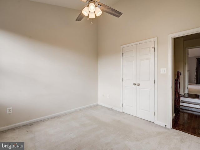 unfurnished bedroom featuring carpet floors, a ceiling fan, baseboards, and a closet