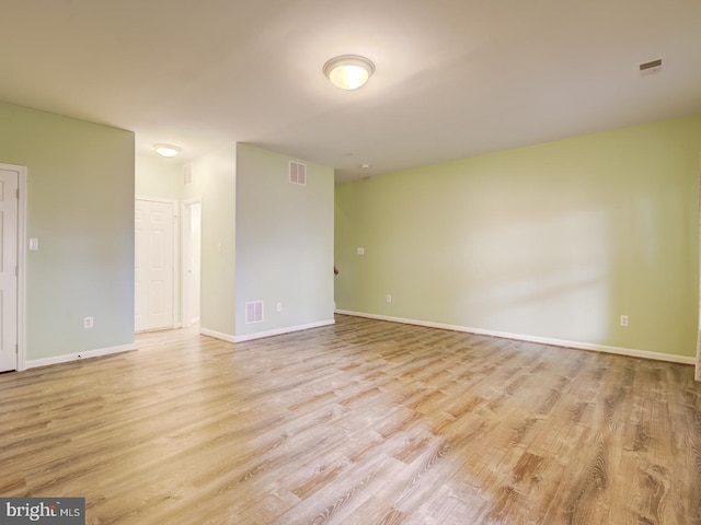 spare room with light wood-type flooring, baseboards, and visible vents