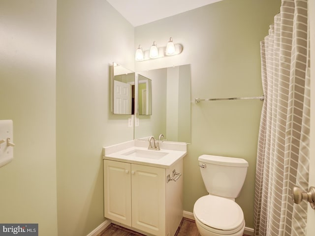 bathroom with vanity, toilet, and baseboards