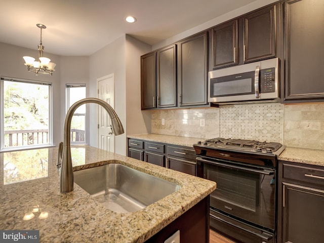 kitchen with stainless steel microwave, backsplash, black gas range oven, a sink, and dark brown cabinets