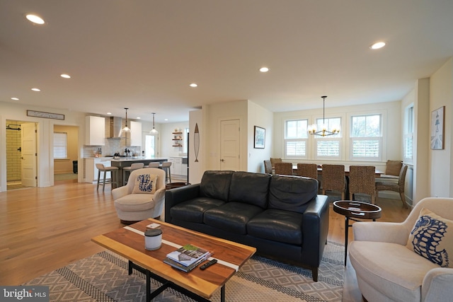 living room featuring light wood-type flooring and an inviting chandelier