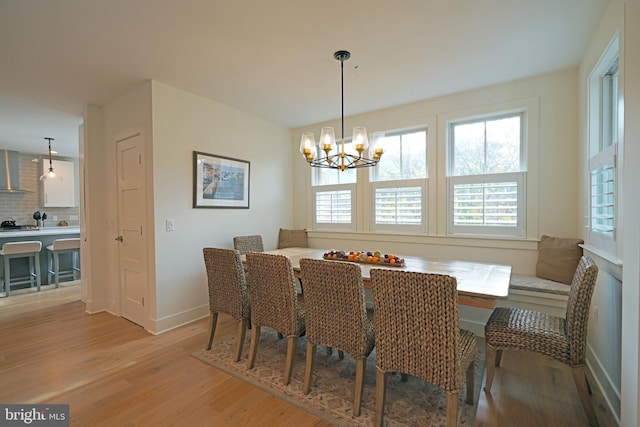 dining area featuring light wood-type flooring and a notable chandelier