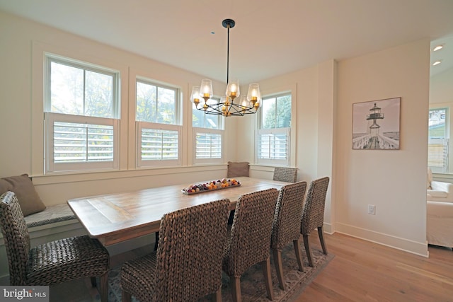 dining space featuring light hardwood / wood-style floors and an inviting chandelier