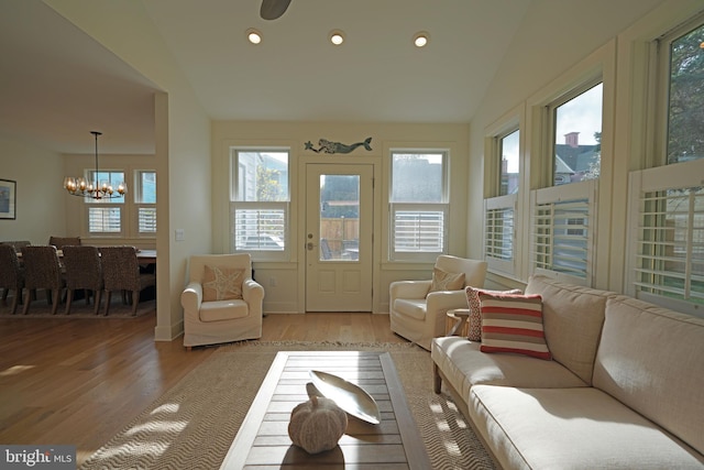 sunroom featuring a chandelier, plenty of natural light, and vaulted ceiling