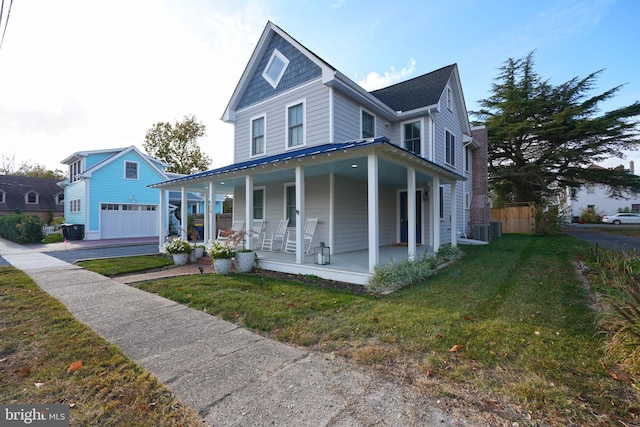 view of front of home featuring a front yard, a garage, and covered porch