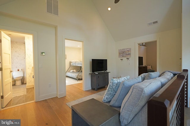 living room featuring high vaulted ceiling, light wood-type flooring, and ceiling fan