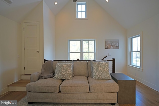 living room with a wealth of natural light, high vaulted ceiling, and hardwood / wood-style flooring