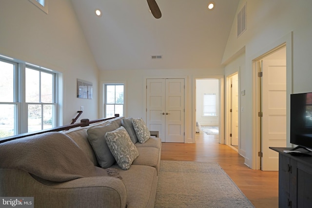 living room with high vaulted ceiling, light wood-type flooring, and ceiling fan