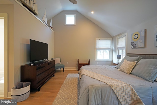 bedroom featuring multiple windows, vaulted ceiling, and light hardwood / wood-style flooring