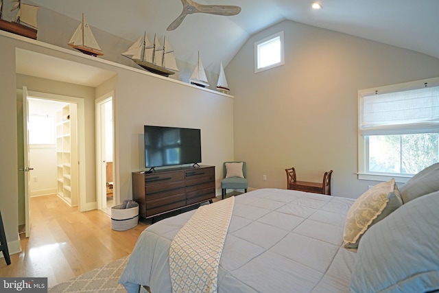 bedroom featuring ceiling fan, vaulted ceiling, light hardwood / wood-style floors, and ensuite bath