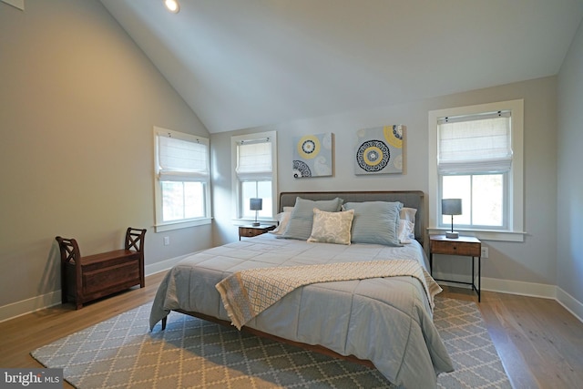 bedroom featuring hardwood / wood-style floors, multiple windows, and vaulted ceiling