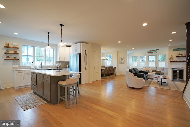 kitchen featuring white cabinetry, light wood-type flooring, sink, and a kitchen island