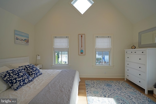 bedroom featuring high vaulted ceiling and hardwood / wood-style flooring