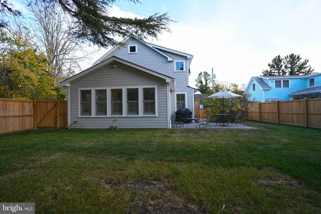 back of house with a lawn and a patio