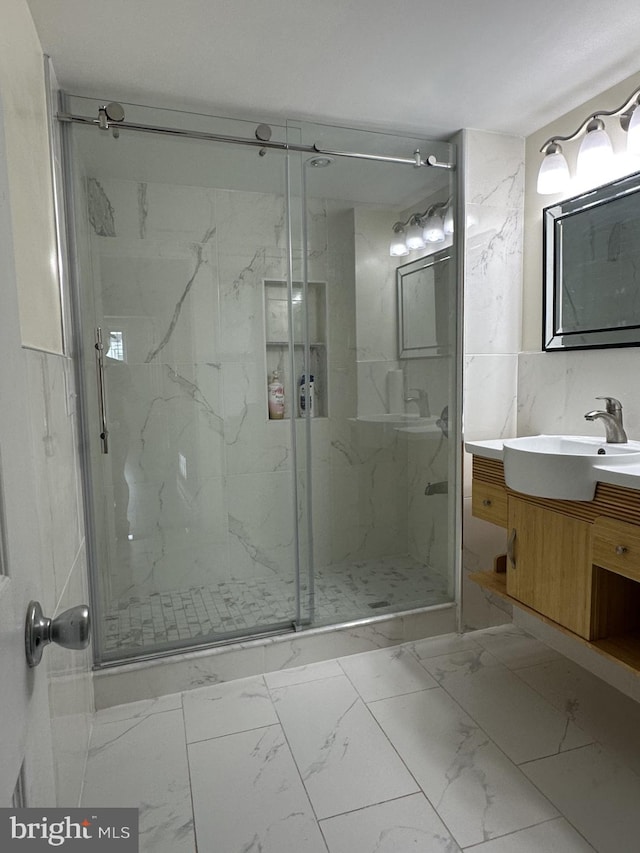 bathroom with tile walls, an enclosed shower, and vanity