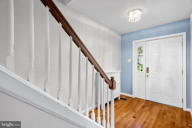 foyer with an inviting chandelier and hardwood / wood-style floors