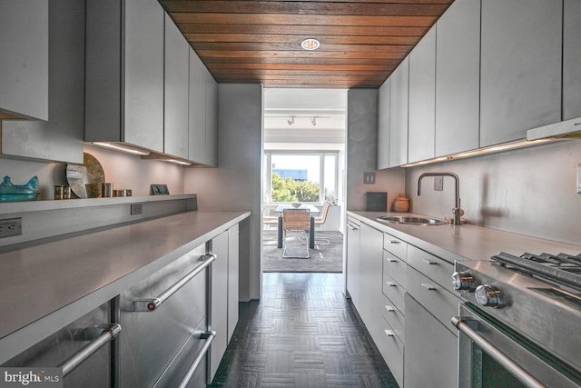 kitchen featuring a sink, wooden ceiling, stainless steel stove, light countertops, and modern cabinets