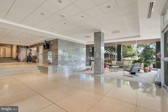 community lobby with floor to ceiling windows and a paneled ceiling