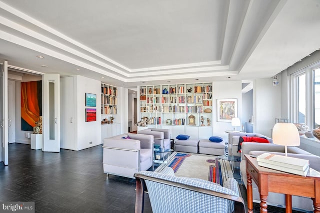 living area featuring a tray ceiling and built in features