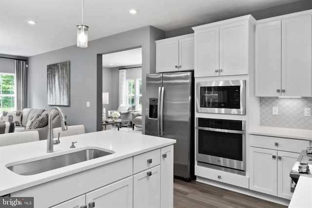 kitchen featuring white cabinets, decorative backsplash, sink, dark hardwood / wood-style floors, and appliances with stainless steel finishes