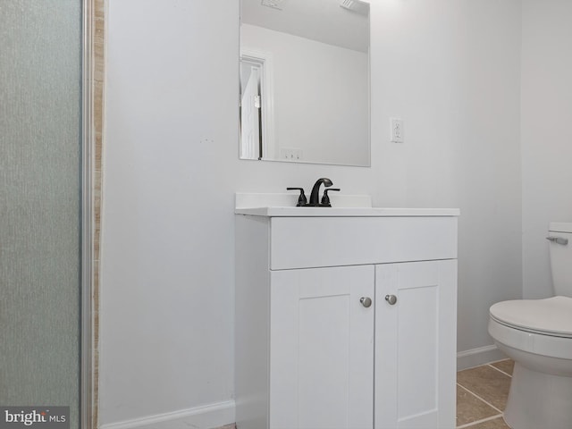 bathroom with vanity, tile patterned flooring, and toilet