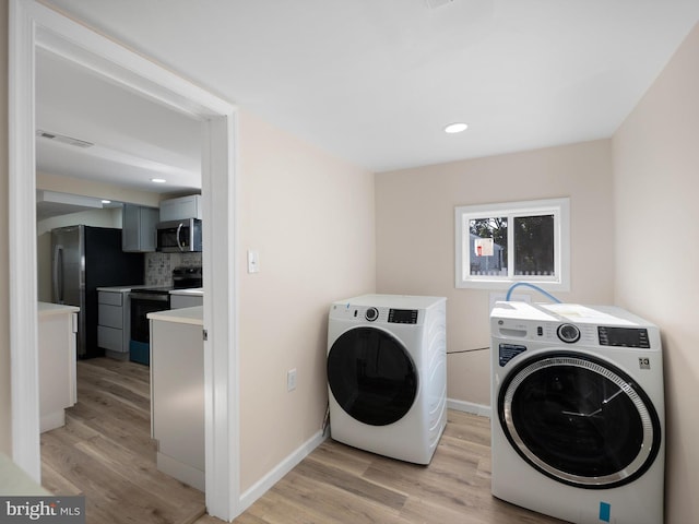 washroom featuring light wood-type flooring and washing machine and clothes dryer