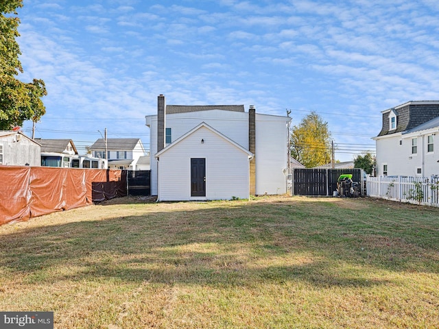 back of house featuring a lawn