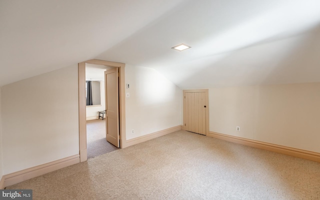 bonus room with light colored carpet and lofted ceiling