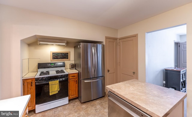 kitchen featuring ventilation hood, stainless steel refrigerator, and white gas range oven